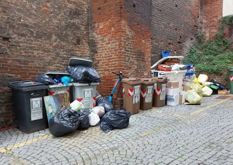 MONCALIERI - Vicolo Cotta invaso dai rifiuti abbandonati fuori dai cassonetti: fioccano le lamentele